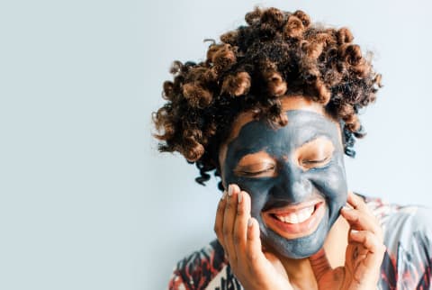 Smiling woman putting on face mask
