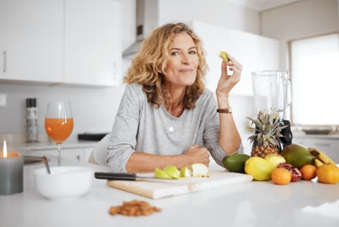 woman eating and smiling in kitchen