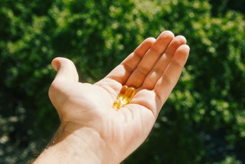 Hand Holding Capsules of Hemp Oil