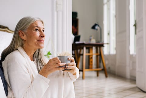older woman sitting with coffee cup