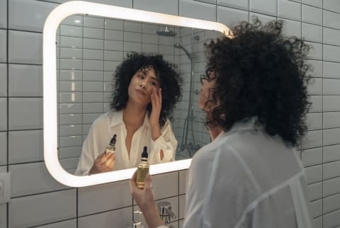 Woman doing skincare in the mirror