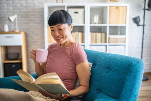 Woman reading a book & sipping coffee