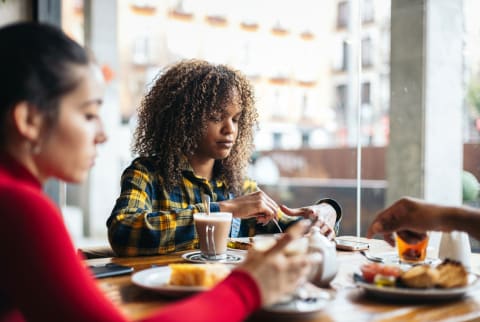 Woman having breakfast with friends looking at plate