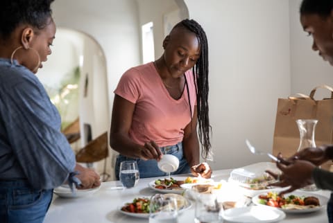 Woman And Friends Cooking And Having Lunch Together