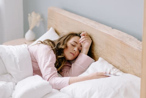 Sleeping Young Woman In Bed With White Linen