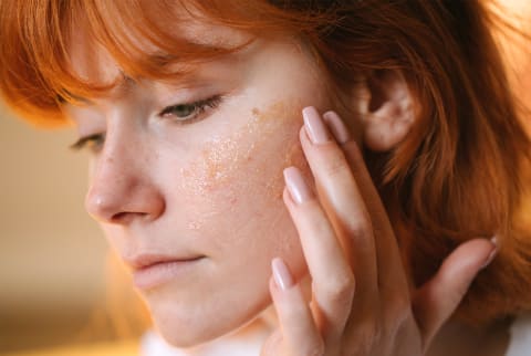 Woman applying skin care to face