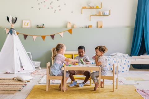Three Children Having a Tea Party in a Child's Bedroom