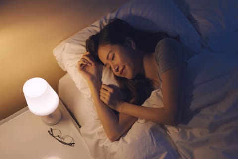 Women sleeping in bed with a nightlight