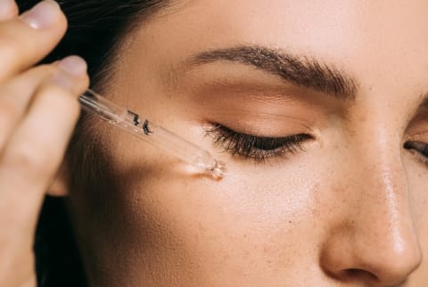 woman putting on serum