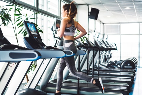 Woman running on treadmill with plants
