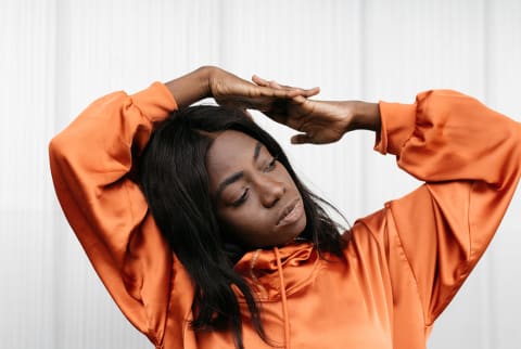 woman stretching in an orange jacket