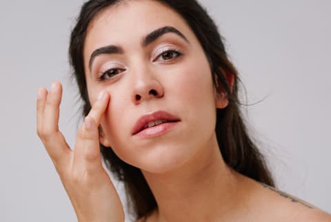Young Woman Applying Eye Cream to Undereye 