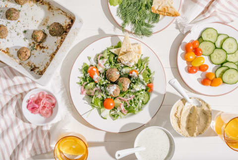 A healthy Mediterranean inspired salad with lamb, pita, hummus, dill, cucumber, and greek yogurt dressing