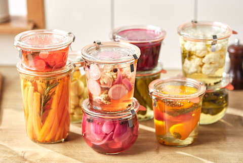 Different Types Of Marinated Vegetables In Glass Jars.