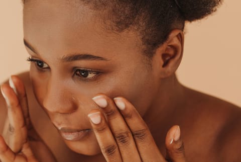Close up of black woman applying skin care product
