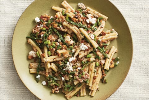 Pasta dish with rosemary walnuts and feta on a green plate
