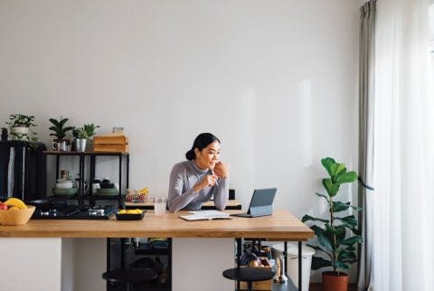 woman sitting at desk looking at ipad