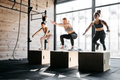 Women doing box jumps at a gym