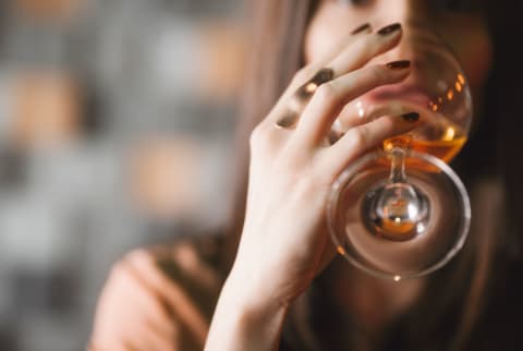 Close up on a woman drinking a glass of wine