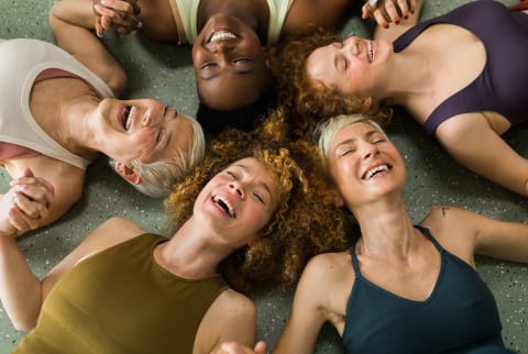 Women laying in a circle at a workout class