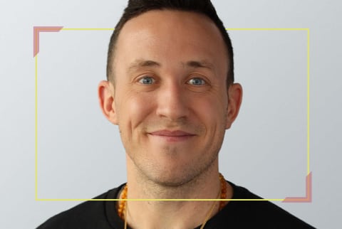 Headshot of man in black shirt and grey background