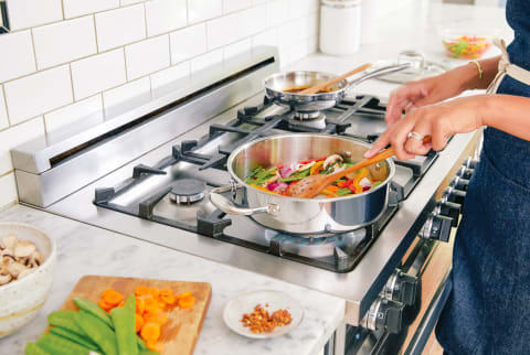 Woman Cooking a Healthy Plant Based Meal on a Gas Stove