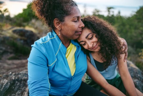 Mother And Daughter Hiking Together At Sunset