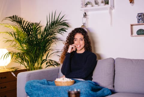 Woman Sitting on Couch Watching TV