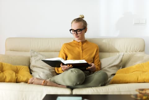 woman reading a book on a couch