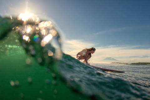 girl surfing a wave on a sunny day