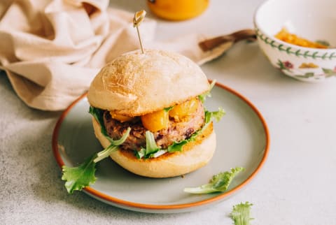 Red beans and quinoa burger topped with caramelized onion and yellow cherry tomatoes