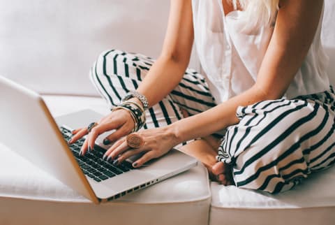 Woman Sitting on Her Couch Working on Her Laptop