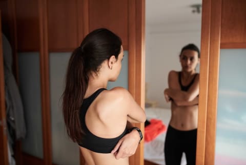Woman looking in mirror after a workout