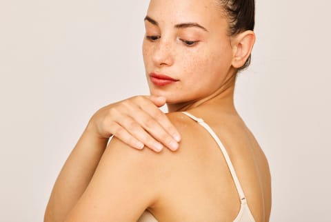 woman with soft skin touching her back