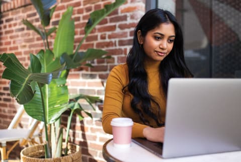 woman sitting outside looking at laptop