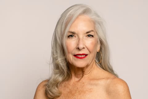 older woman with gray hair on white background and red lips