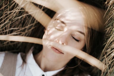 girl with eyes closed in field 