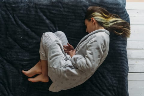 woman holding stomach in pain