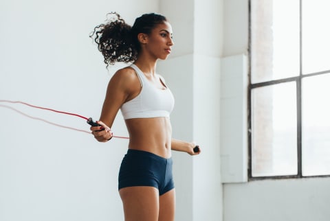 Fit Woman Jumping Rope In A Gym.
