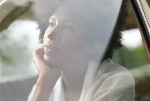 woman looking out window thinking