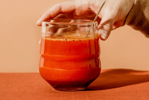 Hand Holding a Glass of Carrot Juice