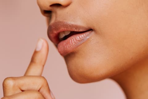 Woman Reaching to Touch the Corner of Her Mouth