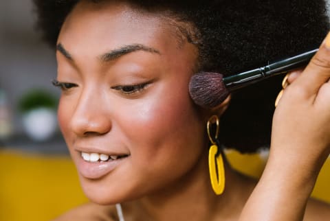 Black Woman Applying Blush And Doing Makeup