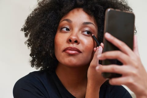 Young Woman Putting On Eyeliner