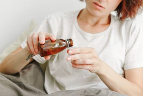 Woman Pouring Cough Medicine