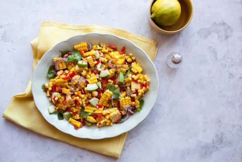 Corn Salad on a plate with lime and marble countertop