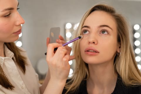 woman getting eye makeup done