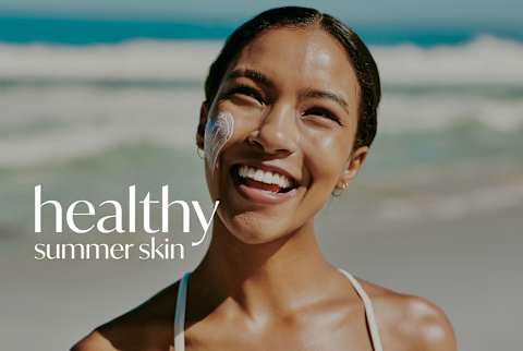 Healthy Summer Skin: woman outside on the beach wearing sunscreen
