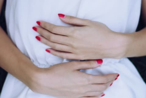 womans hands on stomach