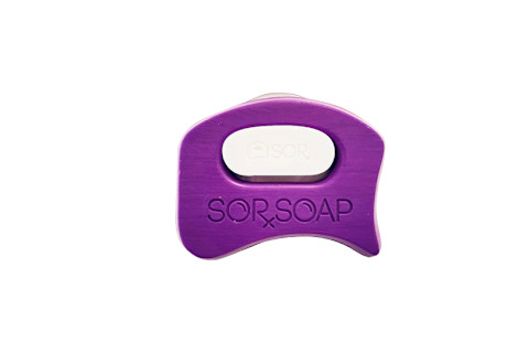 A white bar of soap held within a purple, wave-shaped, handheld scrubbing or soap holder from SorSoap 